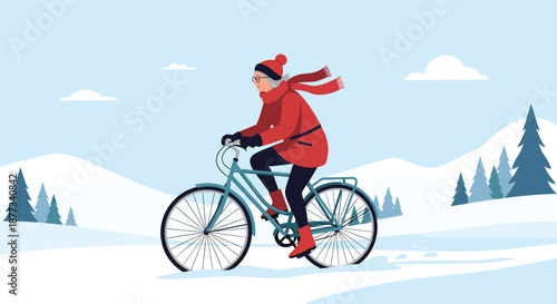 Active senior woman wearing a red winter coat and scarf rides her bicycle through a snowy landscape with mountains and trees.