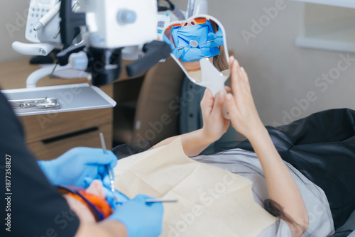 Female patient in dental examination with dentist using tools and mirror for oral check-up