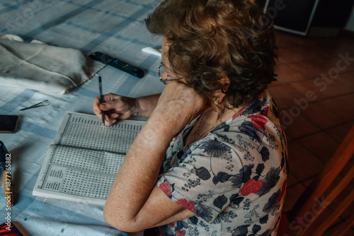 Wallpaper Mural senior woman at home writing puzzles or crosswords Torontodigital.ca