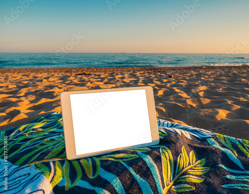 Tablet on beach towel at Firefly Beach with sand and ocean in the background