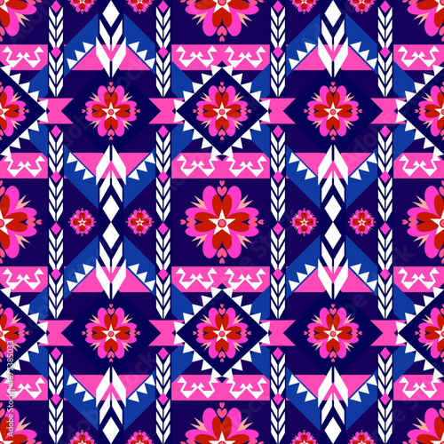 A vibrant seamless geometric pattern featuring ethnic tribal motifs and floral ornaments. The design showcases a modern bohemian style with symmetrical diamond shapes and zigzag lines in turquoise, br