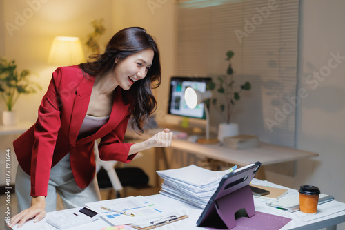 Photos Young Asian businesswoman expresses cheerful excitement and achievement, clenchi