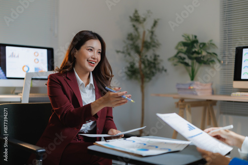 Fotografie Asian businesswoman discussing company reports and financial data with a colleag