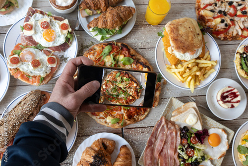 Hand shooting top view sharing brunch food on smartphone