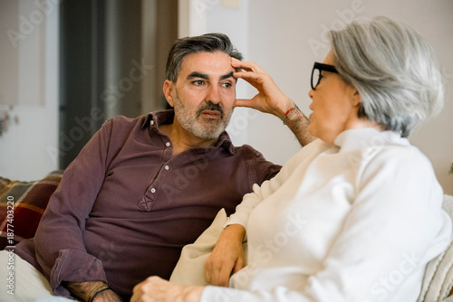 Mature man listening attentively to senior woman at home