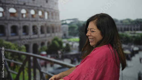 Photos Smiling middle aged hispanic woman pulls rope by coliseum building on balcony in daylight; amusement