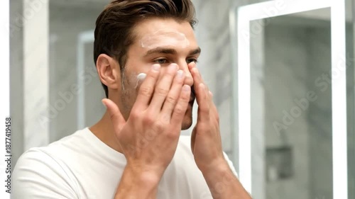 Man applying face cream in a modern bathroom