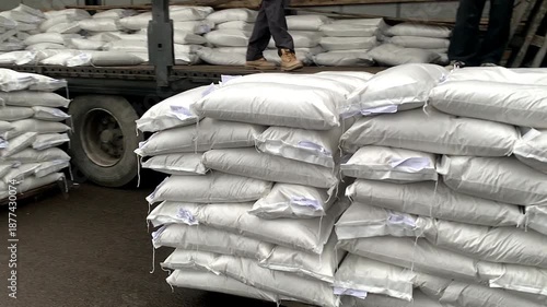 Forklift unloading pallet of sacks from truck.