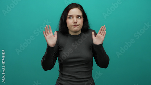 Fotografía Woman brunette shrugging uncertainly against vibrant blue background emphasizing confusion and questioning with gestures