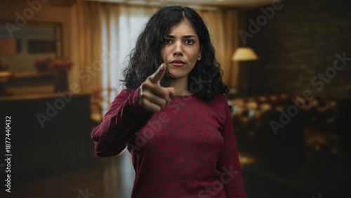 Bild auf Leinwand Woman points finger at camera in studio with stern expression and visible index finger and facial piercings; accusation accountability