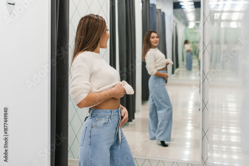 Woman Checking Fit Of Jeans In Dressing Room