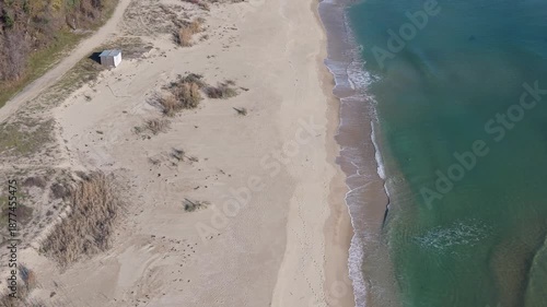 Soft blurred ocean waves meet sandy shore under calm horizon, blue tones, minimalist seascape, tranquil mood, dreamy coastal background scene.