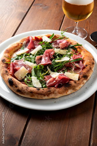 Pizza con rucola, scaglie di parmigiano e prosciutto crudo, cibo italiano 