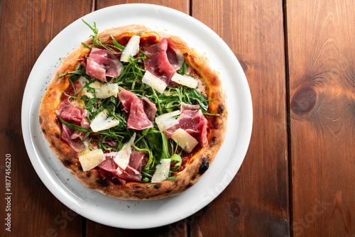 Pizza con rucola, scaglie di parmigiano e prosciutto crudo, cibo italiano 