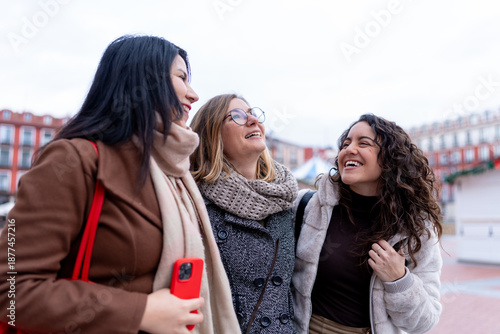 Women friends laughing and sharing winter city moment