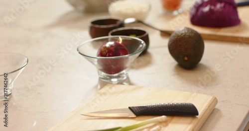 Camera focus pull is revealing ingredients on marble counter from scallions to purple cabbage wedge