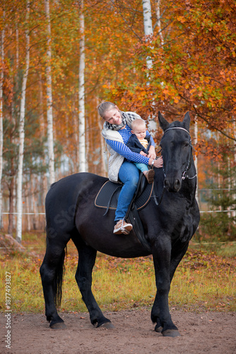 Gentle Mother And Baby Riding Horse In Autumn