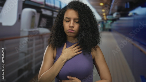 Obraz na plátne Woman experiencing motion sickness on cruise ship feels unwell standing on deck with hand on stomach under sunny seaside setting