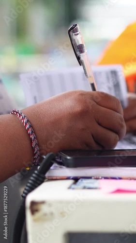 A person counting numbers and writing notes on paper, focused on calculation, planning, or financial work