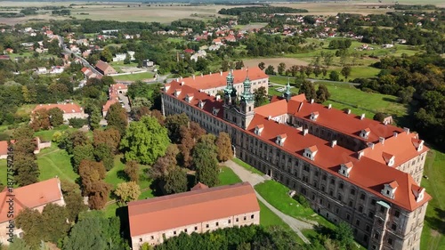 Aerial drone view of Cistercian Abbey in Lubiąż, Lower Silesia, Poland, surrounded by lush green forests, river, and scenic countryside landscape, historic monastery and cultural heritage site