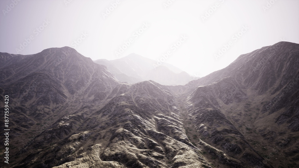 Obraz premium Rugged mountain slopes rise dramatically under a soft, glowing light. The landscape is defined by sharp ridges and textured terrain, inviting exploration and wonder.