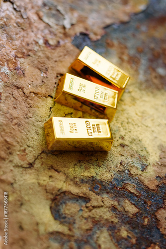 Gold bars placed on a rusty metal background