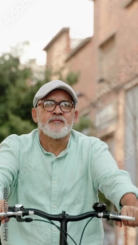 Mature man with beret and glasses enjoying a healthy lifestyle while riding a bicycle