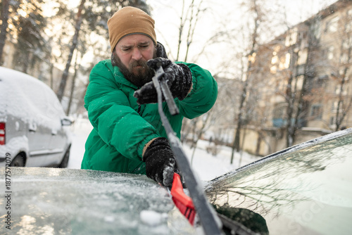Man Scraping Snow and Ice off Car Wiper Blade