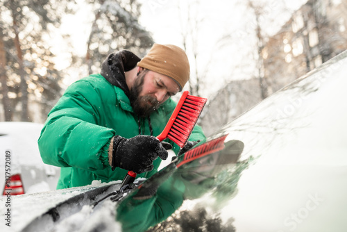 Man Removing Ice and Snow from Under Car Wipers