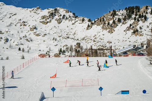 Fotografie Group of skiers and snowboarders standing on a snowy ridge, enjoying panoramic mountain view during winter vacation