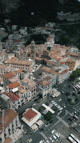 Aerial drone view of the Amalfi Coast in Italy showing blue sea, luxury yachts, coastal city, and mountains. Scenic Mediterranean landscape captured from above for travel and tourism concepts.