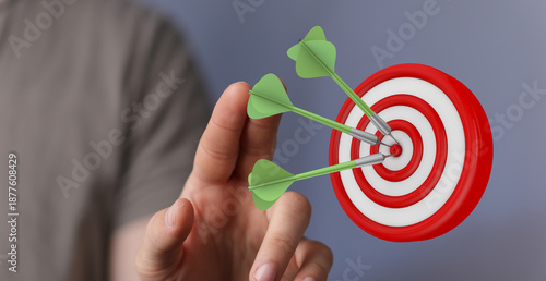 Hand throwing darts at a da...