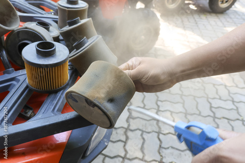 Schilderij op canvas Mechanic hand holding dirty air filter cleaning dust with air compressor blow gu