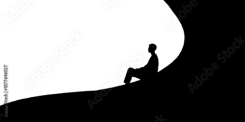 Silhouette of a young male sitting on a hill with clear sky background