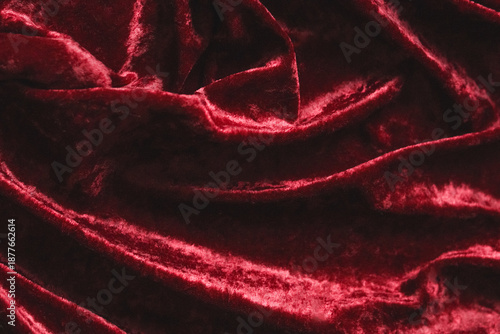 Crushed red velvet fabric creating rich textured drapery, showing luxurious soft textile surface with elegant folds