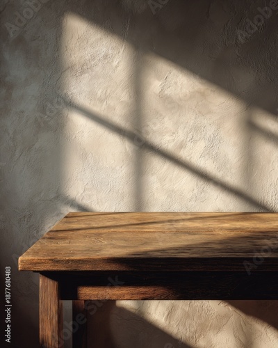 Minimal empty wooden table with dramatic window light and textured wall
