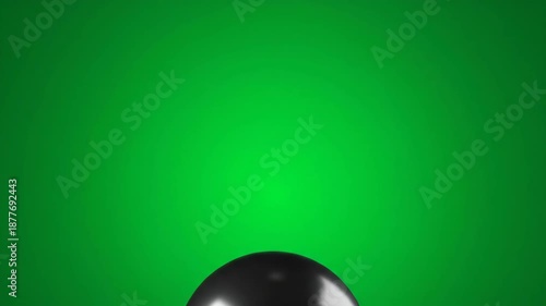 A glossy black spherical object rests at the bottom of a vivid green gradient backdrop. Its form reflects light, appearing smooth