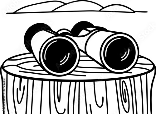 Binoculars placed on a wooden stump with distant hills in the background outline