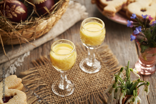 Foto Two glasses of Eiecognac with Easter decoration and spring flowers