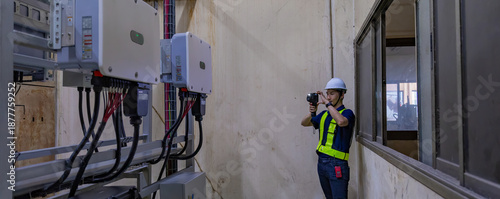 Fotografija Inspector examination of photovoltaic modules using a thermal imaging camera
