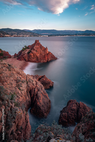 Red volcanic rock cliffs of Pointe de l'Aiguille at sunset, Théoule-sur-Mer, France.