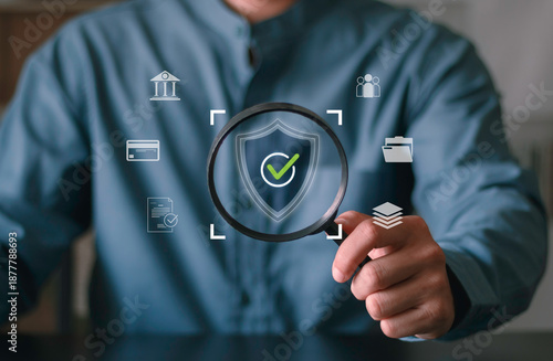 Data protection, compliance audit, privacy control, financial security, risk management, and regulatory verification. Business professional using magnifying glass to inspect digital shield icon.