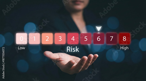 Business professional holding a digital risk assessment scale with management options from low to high risk
