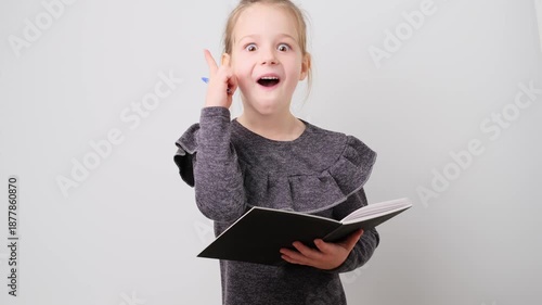 Thoughtful pretty school girl notes, writing down thoughts with pen into notepad notebook diary, to do list, good idea