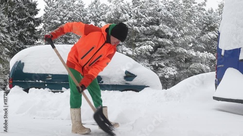 Slow motion camera shot of woman shoveling snow from the yard. Heavy, snowy winter, independent female.