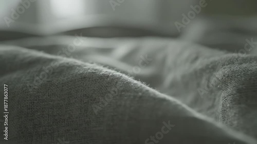 Extreme close-up macro shot of soft, wrinkled grey fabric texture showing fluffy material fibers and abstract cloth background detail