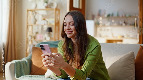 Satisfied woman shopping online using mobile phone app sitting sofa closeup