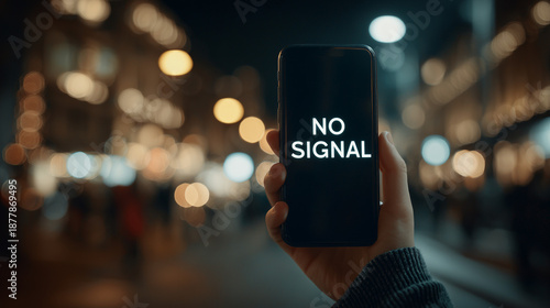 Hand holding smartphone with no signal error on screen at night in urban setting with bokeh lights perfect for mobile connectivity ads and tech outage visuals
