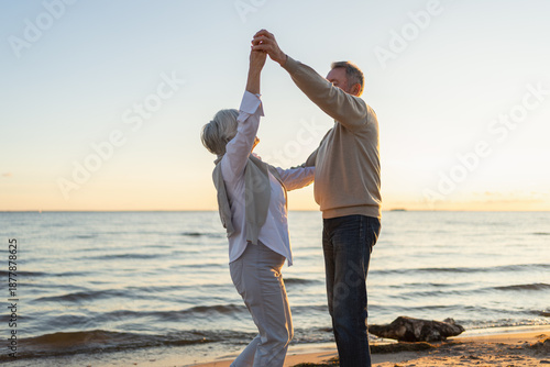 Keep moving. Romantic senior mature couple dancing together on beach outdoor recreation. Happy smiling family retired man woman husband wife having fun enjoying time together. Family moment love care