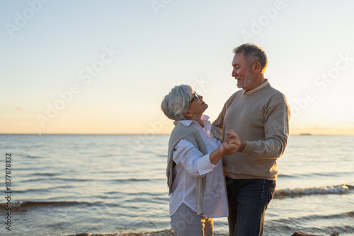 Keep moving. Romantic senior mature couple dancing together on beach outdoor recreation. Happy smiling family retired man woman husband wife having fun enjoying time together. Family moment love care